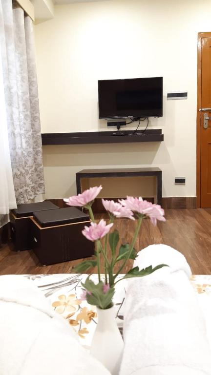 a room with a vase with pink flowers in it at Denzong Khim in Gangtok