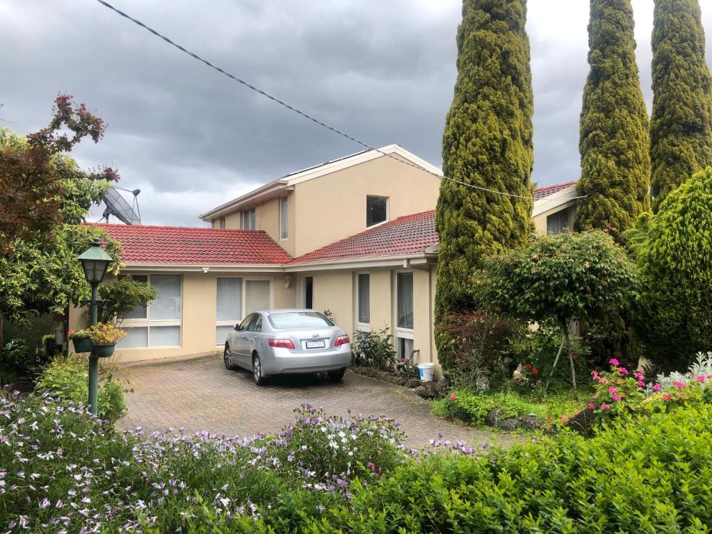 a house with a car parked in the driveway at Rose Bed and Breakfast in Wantirna