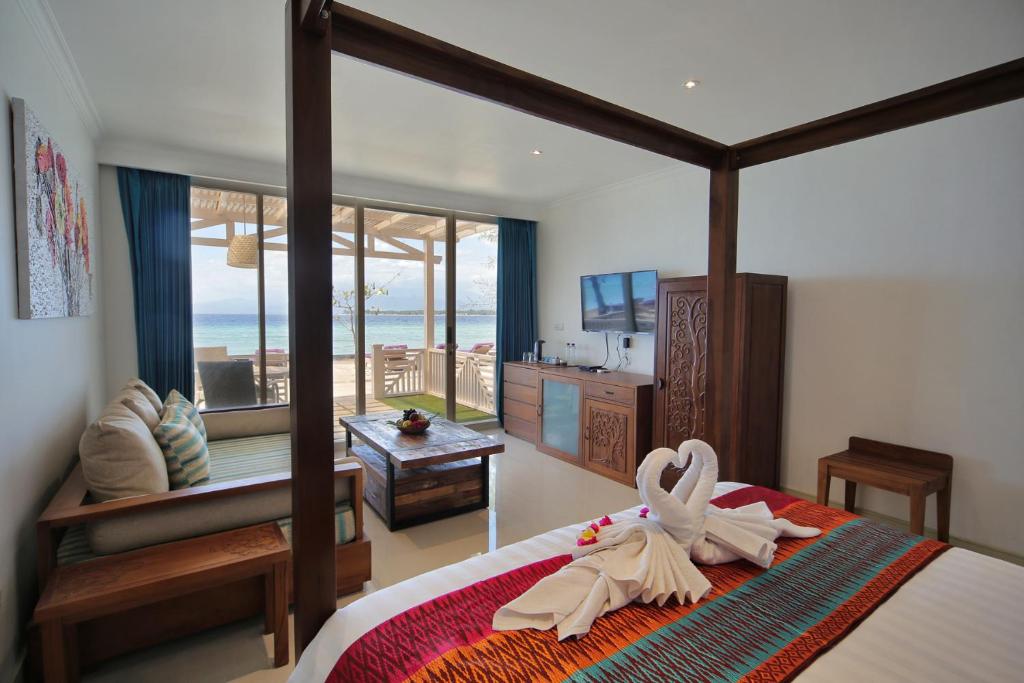 1 dormitorio con 1 cama con toallas en Gili Meno Mojo Beach Resort, en Gili Meno