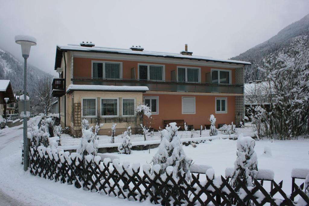 ein schneebedecktes Haus vor einem Zaun in der Unterkunft Haus Dixer in Bad Gastein