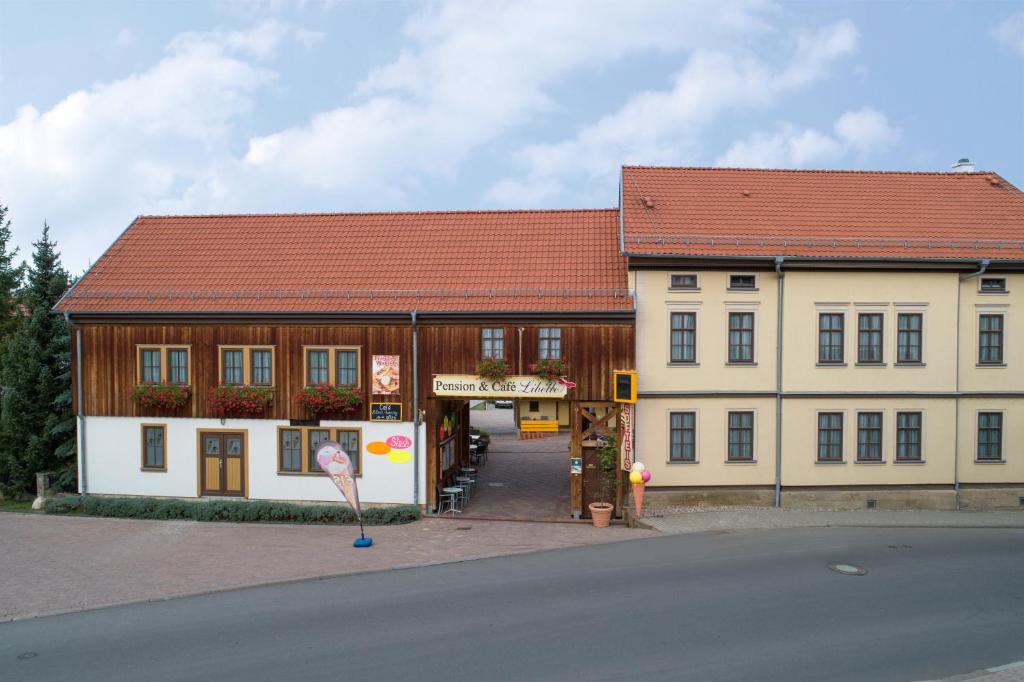 um grande edifício com um telhado vermelho em Pension-Café-Libelle em Elxleben bei Arnstadt