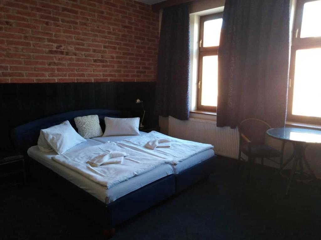 a bed in a room with a brick wall at Hotel Chicago in Chomutov