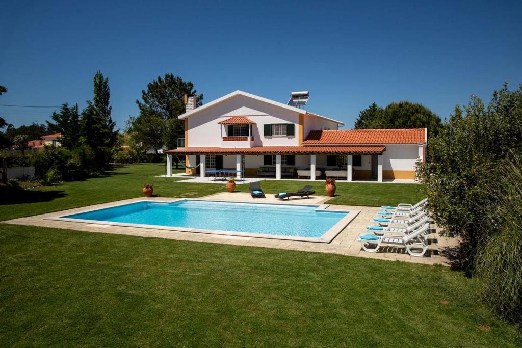 a house with a swimming pool in front of a house at Quinta Turki Malika in Óbidos