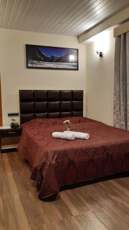 a bedroom with a large bed with a red bedspread at Denzong Khim in Gangtok
