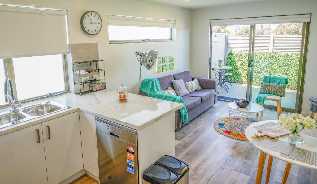 a kitchen and living room with a couch and a table at U201 Brunswick Living Top floor Balcony Close to APT and CBD Free Wifi Tram at Doorstep in Melbourne