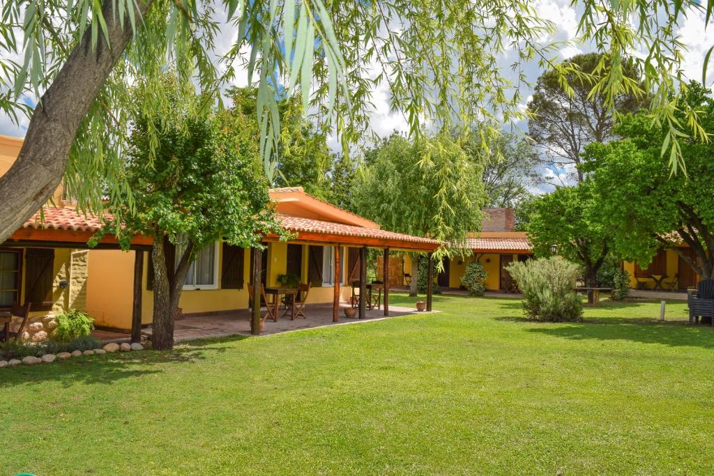 a guest house with a garden and trees at Los Sauces Posada in Nono