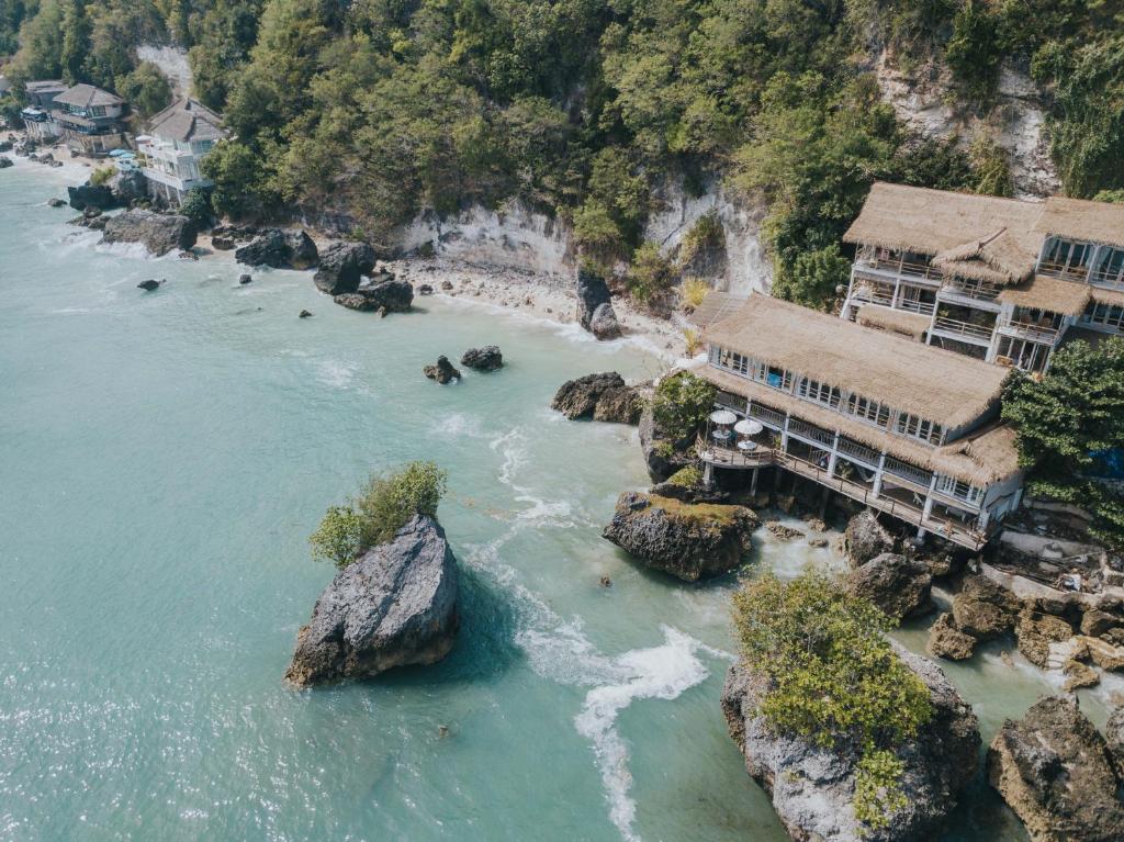 an aerial view of a river with houses and rocks at Dreamsea Bali in Uluwatu