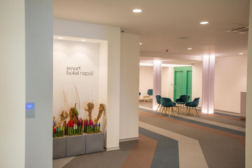 ナポリにあるSmart Hotel Napoliの椅子と緑のドアが備わるオフィスロビー