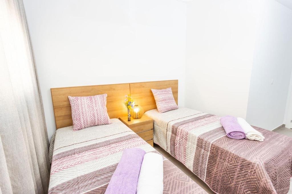 two beds in a room with purple sheets and pillows at Calpe Beach in Calpe