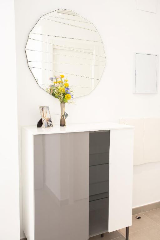 a mirror on top of a white desk with a vase of flowers at Calpe Beach in Calpe