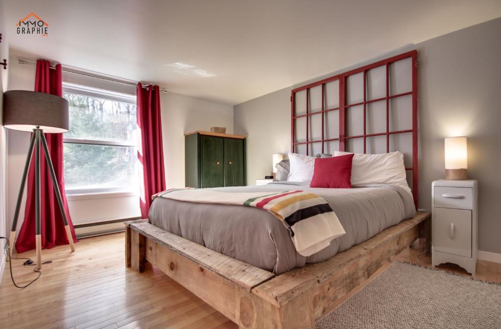 a bedroom with a bed and a window at Maison Cadorette in Saint-Jean-des Piles