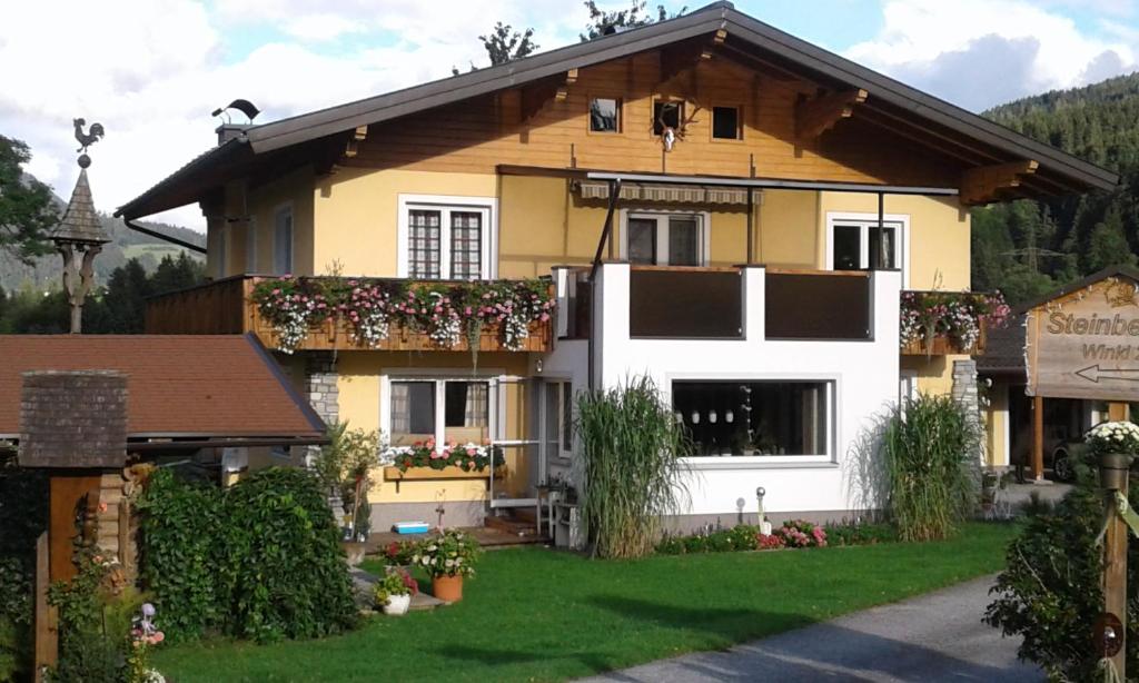 ein Haus mit Blumen auf der Vorderseite in der Unterkunft Ferienwohnung Steinberger in Bischofshofen