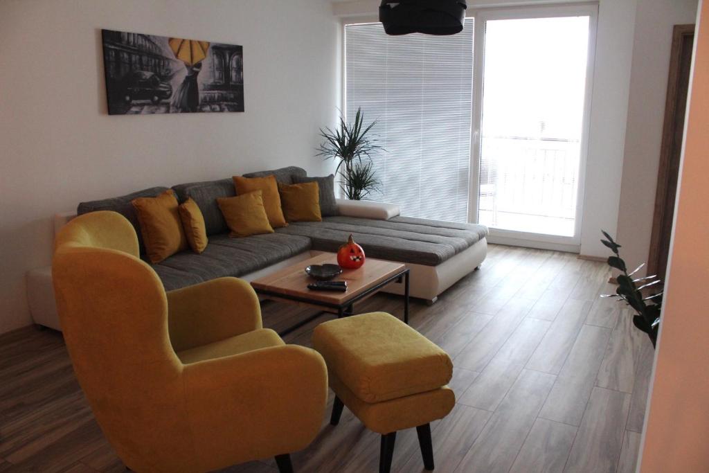 a living room with a couch and two chairs at Apartment ANNO in Dunajská Streda