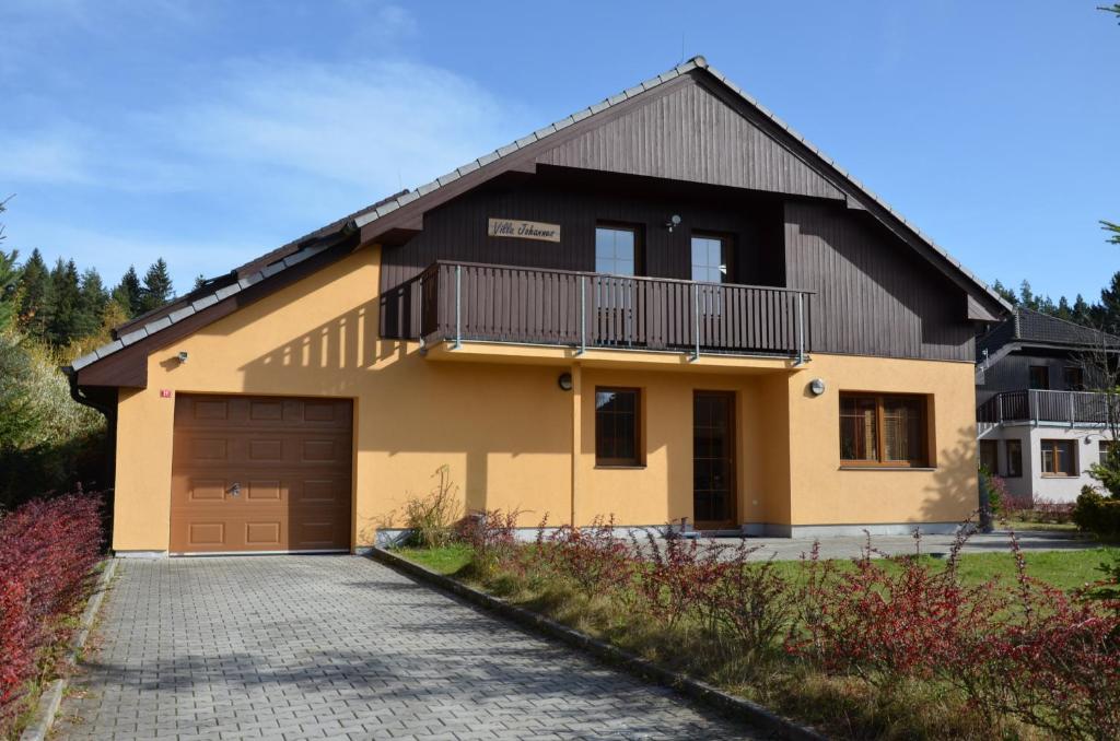a house with a balcony and a driveway at Villa Lipno Lake in Lipno nad Vltavou