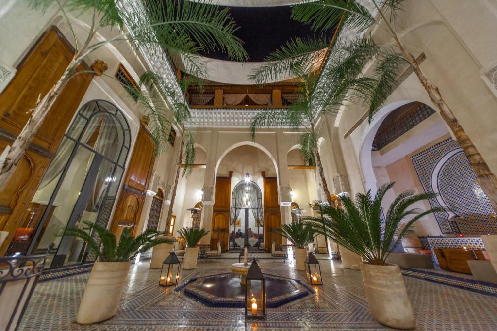 a lobby with palm trees in a building at Riad Said in Fès