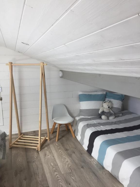 a teddy bear sitting on a bed in a room at Les Tignoliers in Tignieu-Jameyzieu