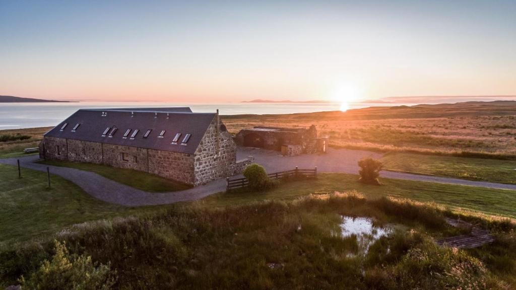 una vista aérea de un edificio en un campo con puesta de sol en Monkstadt No 7 - Flora's Secret, en Portree