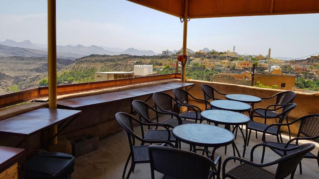 a row of tables and chairs on a balcony with a view at Basmat almisfah in Al Ḩamrāʼ