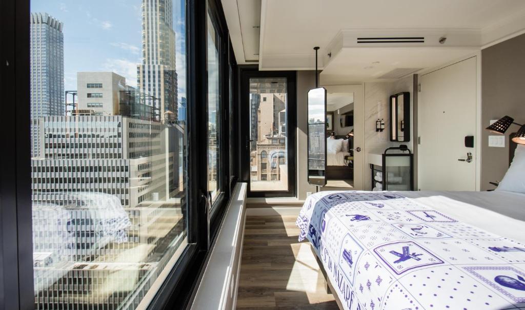 a bedroom with a bed and a view of the city at Pestana Park Avenue in New York