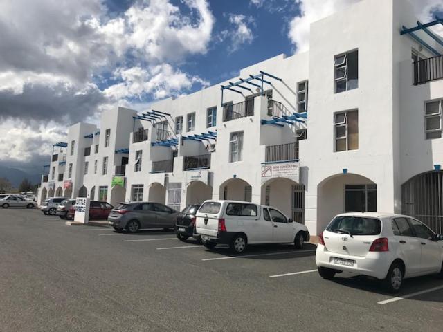 a parking lot with cars parked in front of a building at Modern secure apartment in Strand - Little Greece in Strand