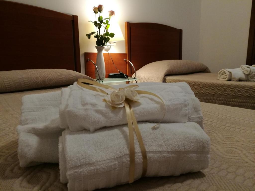 een stapel handdoeken bovenop een bed bij HOTEL PRINCIPE in Forlì