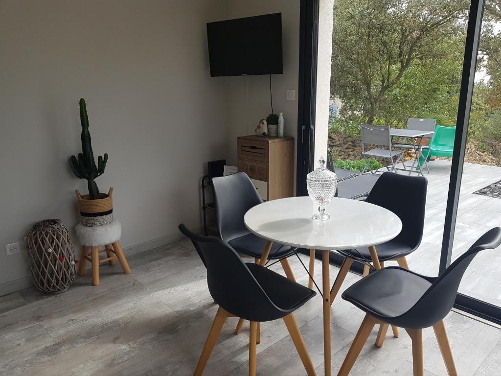 a dining room with a white table and chairs at gite A L' ÉVIDENCE in Mornas