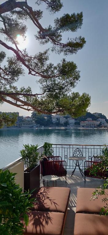 a view of a body of water with two chairs and a bench at Splendid Hôtel & Spa in Bandol