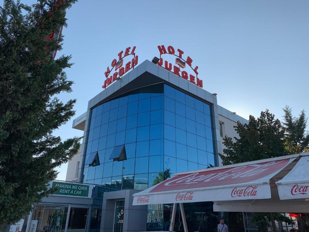 Un edificio con sopra un cartello di cocacola di Hotel Jurgen a Rinas
