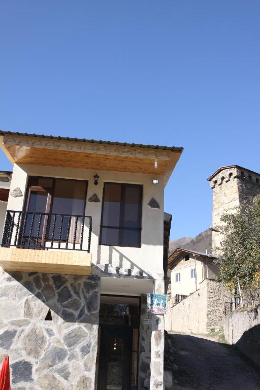 a building with a balcony on top of it at Eka's guest house in Mestia