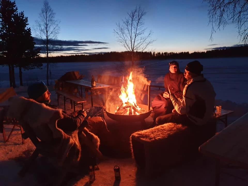 Eine Gruppe von Menschen, die um ein Feuer herum sitzen in der Unterkunft Storbo Adventure Camp in Storbo