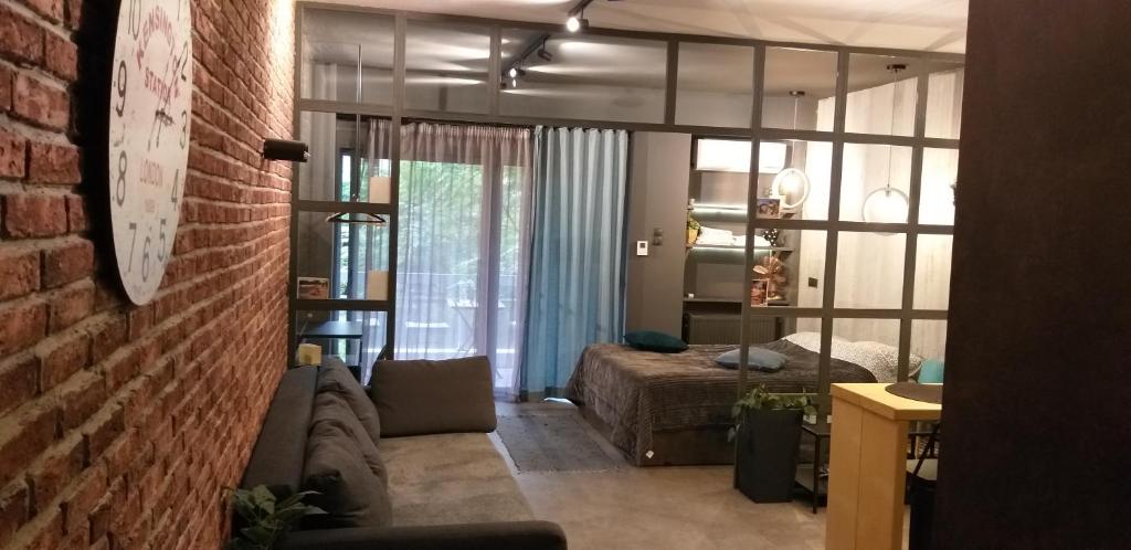 ein Wohnzimmer mit einem Sofa und einem Bett in der Unterkunft Agias Sofias suite in Thessaloniki