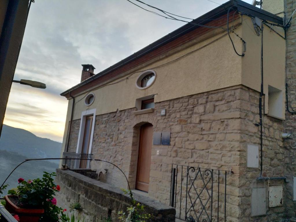 ein Steingebäude mit einem Fenster und einem Balkon in der Unterkunft AURIGA in Pietrapertosa