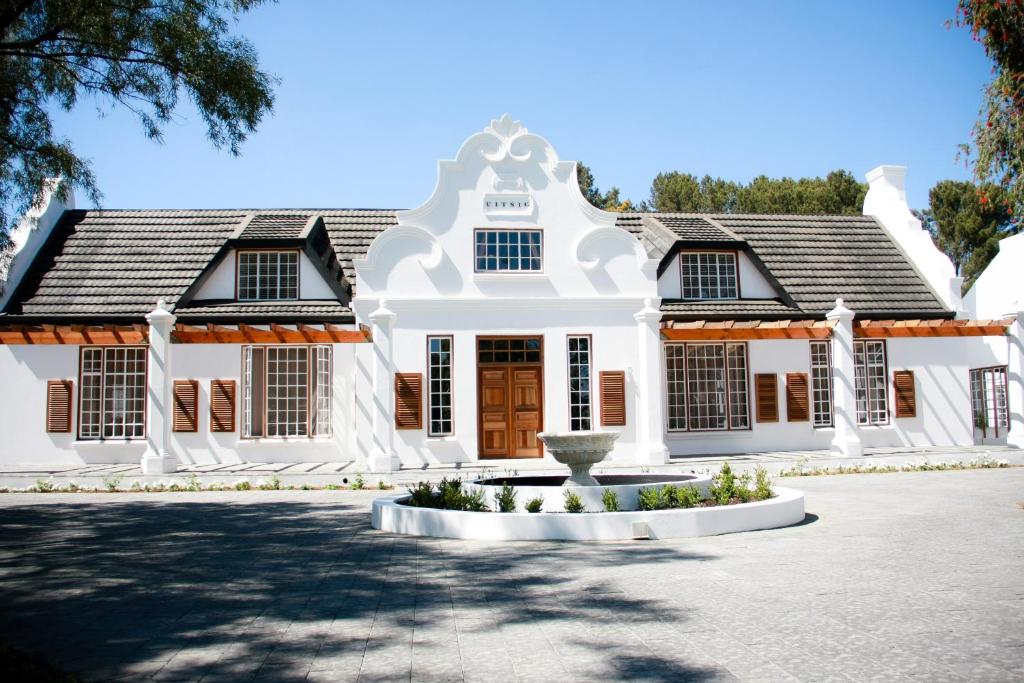 a white house with a fountain in front of it at Uitsig Boutique Hotel in Welkom