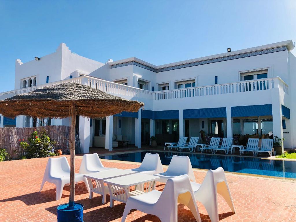 a villa with a pool and chairs and an umbrella at Villa Dar Jbila Tanger in Tangier