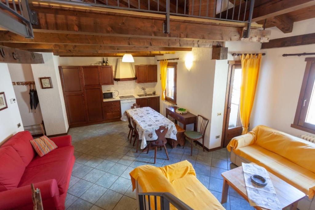 a living room with a table and a kitchen at Chalet Mew in La Thuile