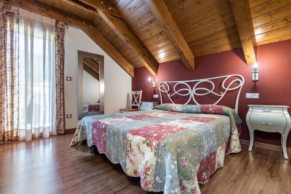1 dormitorio con 1 cama en una habitación con paredes rojas en Casa Bergua, en Víu