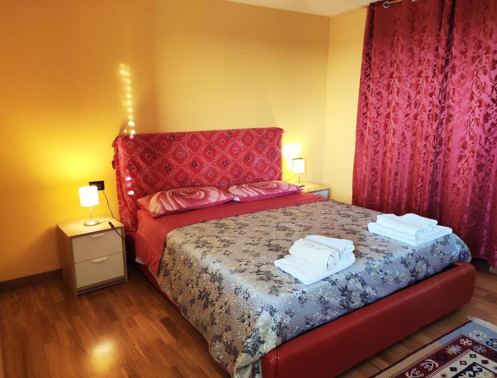 ein Schlafzimmer mit einem roten Bett mit zwei Handtüchern darauf in der Unterkunft Villetta tra gli agrumeti in Corigliano Calabro