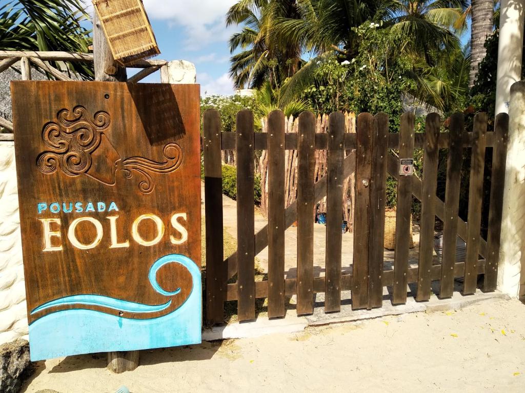 una cerca de madera con un cartel que dice pismoolis en Pousada Eolos, en Barra Grande