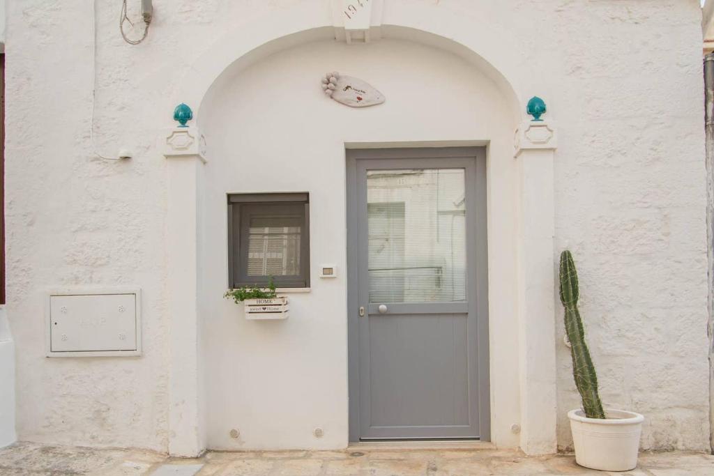 una puerta en un edificio blanco con un cactus en A Casa di Rosy, en Ostuni