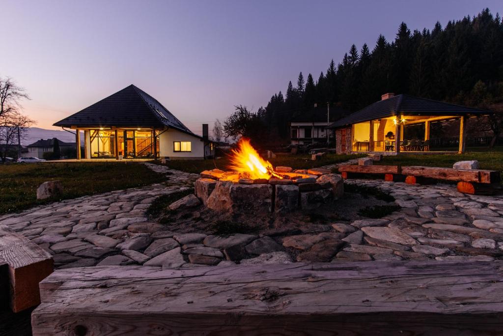 a fire pit in a yard in front of a house at Loft Chalet in Gura Humorului