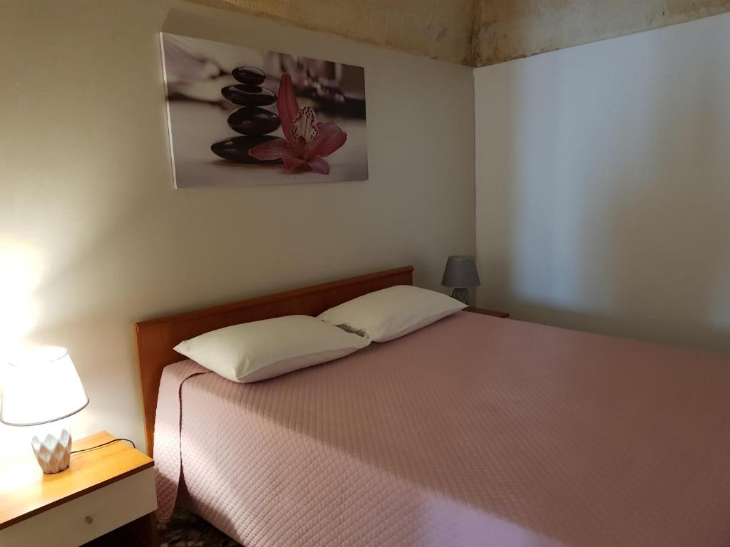 1 dormitorio con 1 cama con 2 almohadas en Il Vallone, en Crispiano