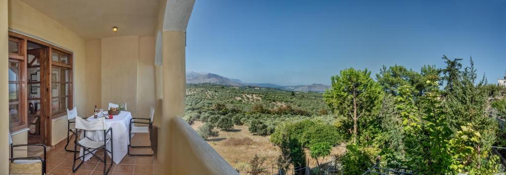 a balcony with a table and chairs and a view at Charming Country House with View in Episkopí- Rethimno