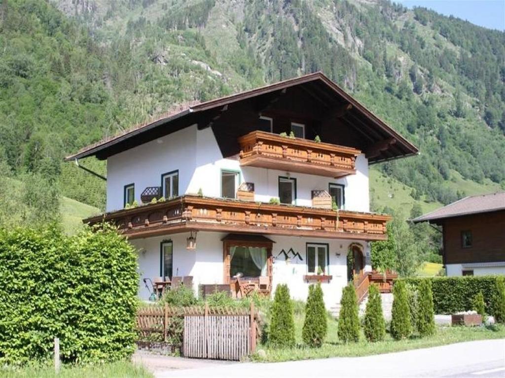 uma grande casa branca com uma montanha ao fundo em Chalet Charlotte em Fusch an der Glocknerstraße