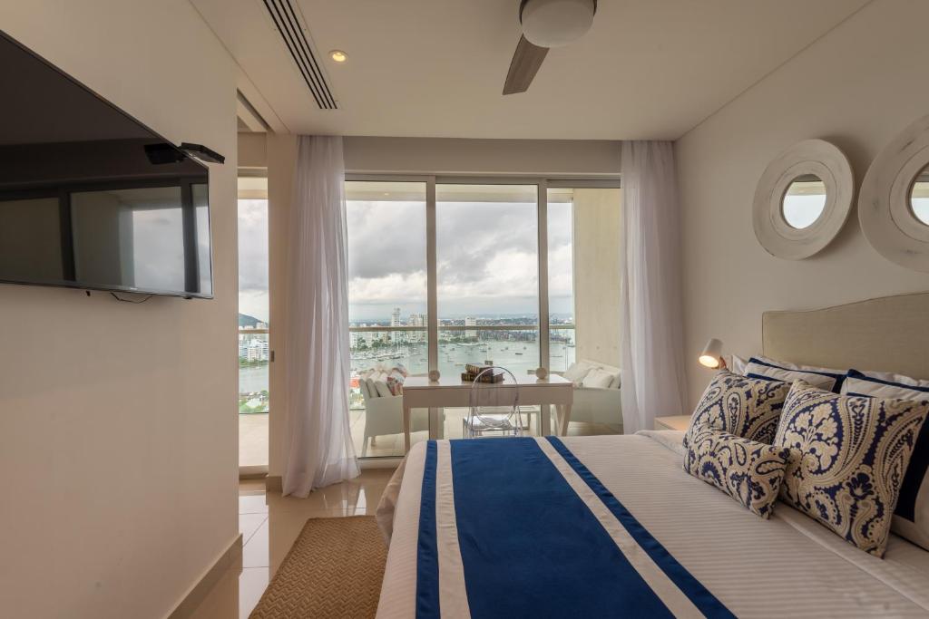 a bedroom with a bed and a view of the ocean at Classy 1 BR, Pool, Gym near Downtown Cartagena by Huespedia in Cartagena de Indias