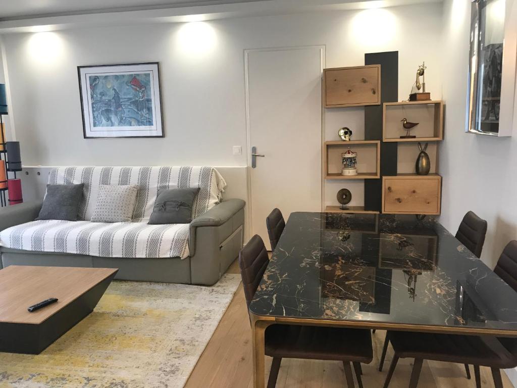 uma sala de estar com uma mesa e um sofá em DEAUVILLE STAR LUXE em Deauville