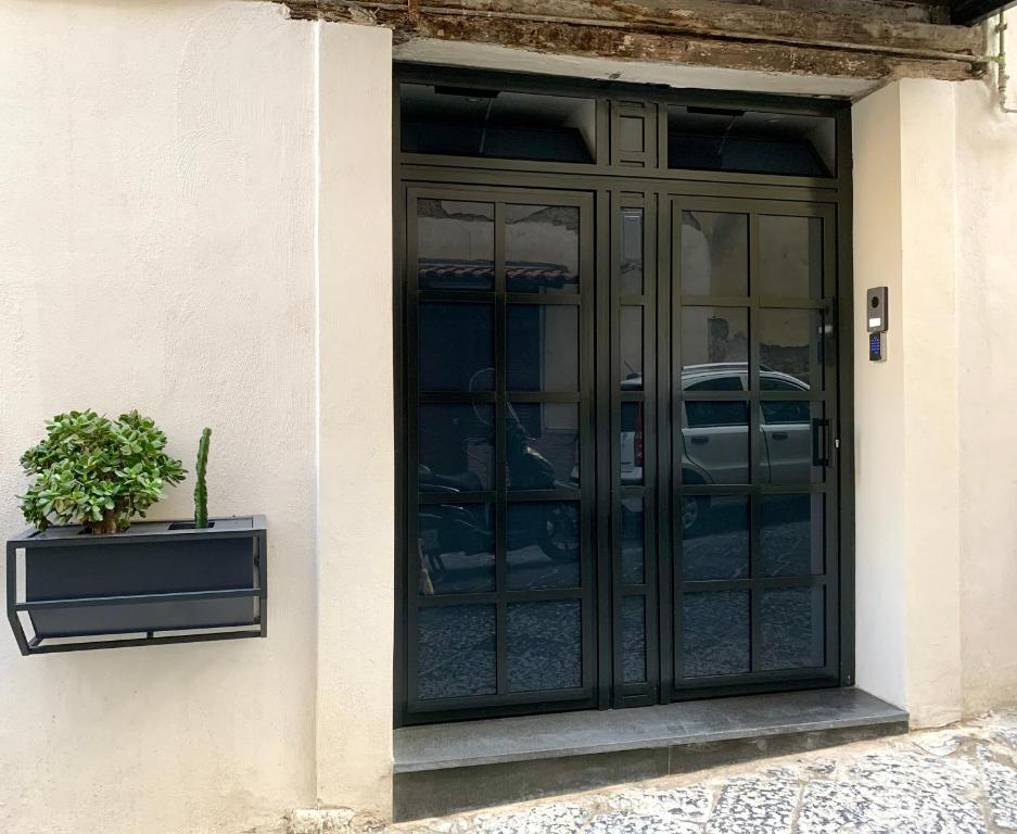 una puerta negra con una maceta al lado de un edificio en SECRET ROOM NAPLES historic center, en Nápoles