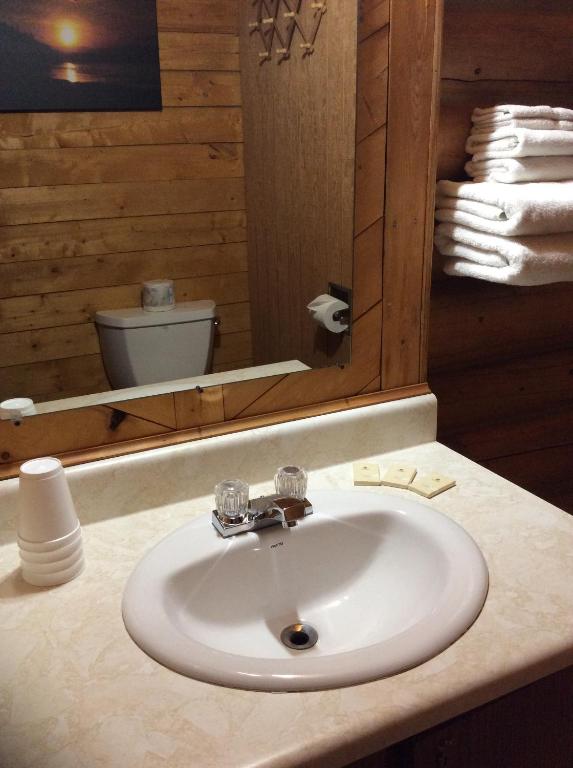 a bathroom with a white sink and a mirror at Double G Service in Muncho Lake