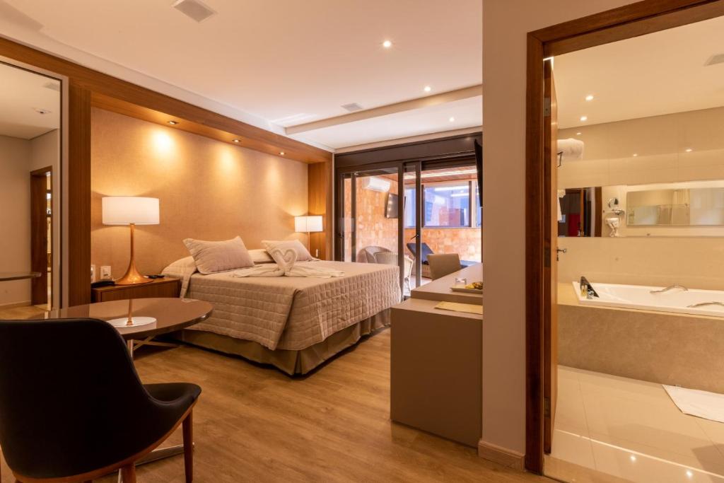 1 dormitorio con 1 cama y baño con bañera en Hotel Bahamas en Dourados