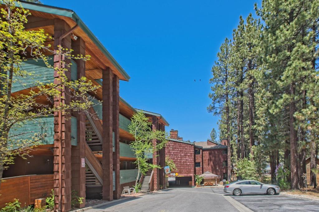 a house clad in wood with a car parked in front at GetAways at Snow Lake Lodge in Big Bear Lake