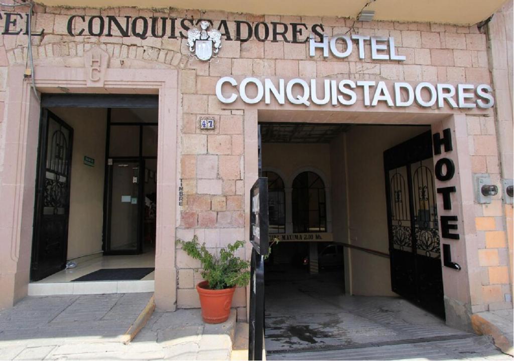 een gebouw met een bord waarop Dores hotelconsultants staan bij Hotel Conquistadores in Zacatecas